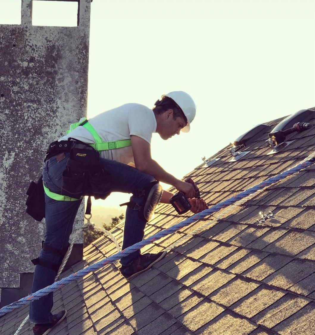rooftop view of Shift founder Colyn Strong installing solar on a home